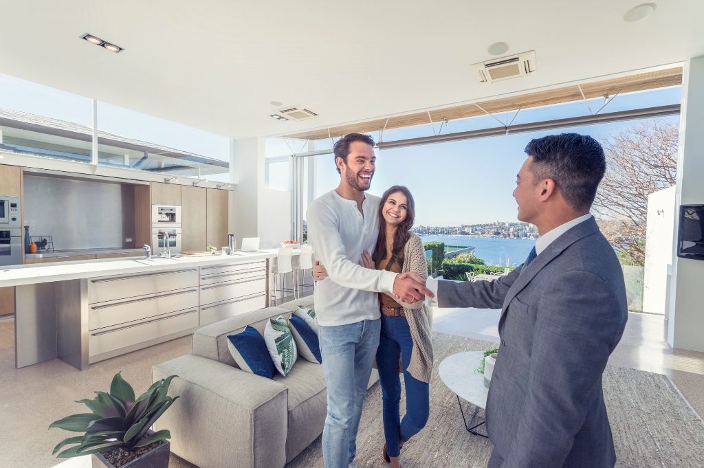 A Real Estate Agent Shaking Hands with a Couple in a Luxury Home.